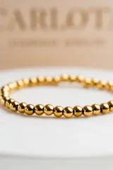 Pulsera elastizada de cuentas de acero quirúrgico con baño de oro 18k.