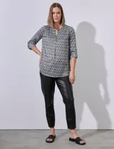 Blusa Ninety de gasa satén con cuello a la base y escote en V. Manga 3/4 regulable con presilla y botón. Estampado geométrico en blanco y negro.