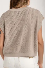 Chaleco sin mangas de tejido de punto color rosado pálido, con textura calada y acabado lurex, corte al cuerpo y cuello redondo.