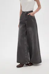 Pantalon de jean gris con efecto lavado, de corte ancho y tiro alto. Cuenta con cierre frontal con botón y bolsillos laterales.