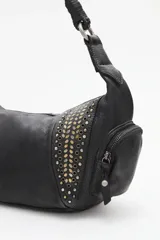 Cartera de cuero vacuno negra, estilo media luna o hobo, con asa de hombro trenzada. Presenta paneles laterales decorados con tachas metálicas doradas y plateadas. Cuenta con bolsillos externos con cierre en los laterales.