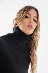 Polera de tejido de punto color negro, con cuello tortuga alto y puños y ruedo acanalados.