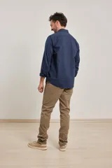 Camisa azul de algodón con elastano, cuello button-down y manga larga.