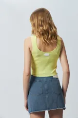 Top negro sin mangas con escote cuadrado, confeccionado en tejido con leve brillo y costuras asimétricas en el frente.