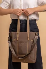 Cartera tipo tote de gran capacidad, confeccionada en nylon color gris con detalles en símil cuero al tono. Cuenta con doble asa de hombro, bolsillo frontal externo y cierre superior.