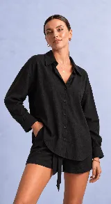 Camisa negra de manga larga, con cuello clásico, cierre frontal con botones y diseño holgado con textura sutil.