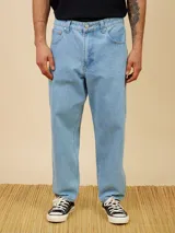 Jean de corte baggy fit en denim color azul claro, con diseño de cinco bolsillos y cierre frontal con botón metálico.