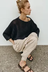 Sandalia plana de serraje color marrón, con doble tira delantera, detalle de hebilla metálica dorada y diseño con separación para el dedo.