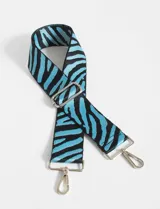 Correa de poliéster con estampado de cebra en azul y negro, con herrajes metálicos plateados y detalles en cuero sintético.
