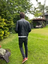 Campera de cuero ovino italiano negra, corte clásico con cierre frontal y bolsillos laterales.