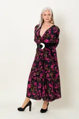 Vestido midi negro con estampado floral fucsia y marrón, escote en V cruzado, mangas largas y cinturón ancho negro con hebilla circular.