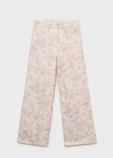 Pantalón jeans de corte wide leg y tiro alto, confeccionado en algodón con estampado floral en tonos suaves. Presenta diseño de cinco bolsillos, cierre frontal con cremallera y botón, y trabillas en la cintura.