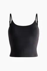 Top corto negro con soutien integrado, confeccionado en tejido funcional con breteles finos ajustables.