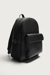 Mochila de diseño minimalista en color negro con acabado texturizado. Cuenta con un compartimento principal con cierre de cremallera, un bolsillo frontal con solapa y compartimento interior para dispositivos electrónicos. Incluye espalda acolchada, banda de sujeción para equipaje, asa de mano y correas de hombro ajustables.