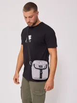 Bandolera negra de nylon con correa ajustable y logo Rusty estampado en blanco.