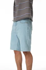 Bermuda de jean celeste, corte recto, largo hasta la rodilla, con costuras contrastadas, parche trasero de ecocuero con logo y confeccionada en Uruguay.