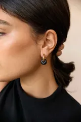 Aros de acero quirúrgico dorado con dije colgante en forma de argolla de piedra natural negra con destellos.