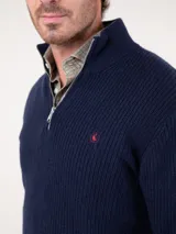 Sweater azul marino de punto inglés con medio cierre y cuello alto. Tiene corte regular fit y logo bordado en el pecho.