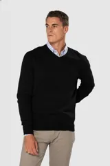 Suéter de tejido fino color azul marino, con cuello en V y manga larga. Presenta un pequeño logo bordado en el pecho.