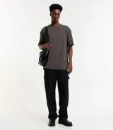 Remera de corte relaxed, confeccionada en algodón de tejido grueso con cuello redondo y mangas cortas.