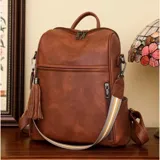Mochila de cuero sintético marrón, amplia y resistente, con compartimento principal y bolsillos frontales y laterales con cierre.