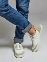 Zapatillas bajas de cuero blanco con puntera y talón de gamuza color beige.