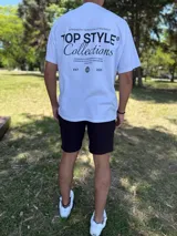 Remera blanca oversize con estampado tipográfico negro en la espalda que incluye texto y un gráfico de un globo terráqueo.