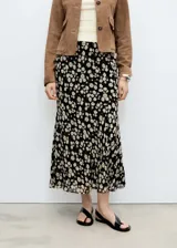 Falda midi de gasa color negro con estampado de pequeñas flores blancas.