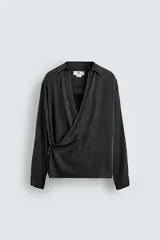 Camisa de corte relajado confeccionada en tejido fluido con mezcla de viscosa y lyocell. Presenta cuello polo, manga larga con puños abotonados y un diseño cruzado con cierre frontal de botones.