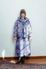 Campera puffer capitoneada con estampado a cuadros en tonos azul, rojo, blanco y gris.