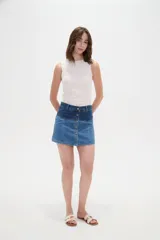 Minifalda de denim con diseño color block que combina dos tonos de azul, tiro alto y cierre frontal con hilera de botones metálicos.