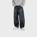 Jean de corte ultra baggy color negro con efecto deslavado y bigotes marcados en los muslos, confeccionado en denim de algodón.