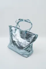 Bolso tipo tote bag color plateado metalizado, con doble asa de hombro.