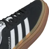 Championes adidas Gazelle Bold de diseño plataforma, confeccionados en gamuza negra con las icónicas tres tiras blancas laterales y detalle de marca en el talón. Presentan una suela de goma apilada en tonos marrones y lengüeta con textura geométrica.