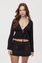 Blusa manga larga de color negro con escote en V profundo y lazo ajustable en el frente, confeccionada en tejido liviano con corte evasé.