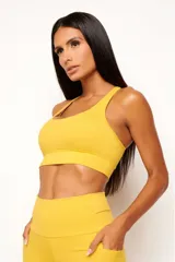 Top deportivo de alto rendimiento con diseño de espalda nadador, confeccionado en tejido técnico con protección UV50+. Presenta un bolsillo interno en el forro frontal y detalles reflectivos.