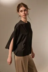 Blusa de satén color negro, con cuello redondo a la base, mangas 3/4 con abertura lateral y diseño holgado.