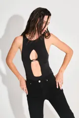 Body negro de seda fría con escote cerrado y abertura en el delantero unida por un aplique metálico con el logo de la marca.