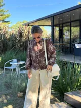 Cartera tipo bandolera de cuero color crudo, con solapa frontal y cierre. Incluye dos correas desmontables, una corta y una larga, y cuenta con bolsillo interior.