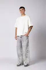 Pantalón de jean con corte baggy y fit oversize, de color gris con efecto lavado ácido. Presenta costuras reforzadas y diseño de pierna ancha.