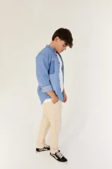 Camisa celeste de jean con cuello mao, manga larga con puños abotonados y bolsillo en el pecho.