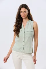 Camisa sin mangas de lino color verde claro, con cuello mao, cierre frontal con botones y dos bolsillos plaqué con solapa en el pecho.