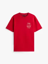 Remera roja de algodón con cuello redondo y manga corta. Estampado frontal con el logo de Tommy Hilfiger en color dorado.