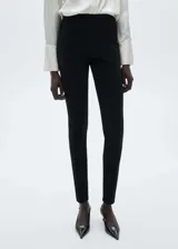 Pantalon slim fit de tejido de punto con cintura elástica, costuras frontales decorativas y cierre con cremallera en los bajos.