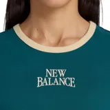 Remera New Balance ringer color verde oscuro con detalles en beige en el cuello y los puños, manga corta, calce al cuerpo y bordado frontal con el logo de la marca.