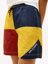 Shorts de nailon con diseño color block en rojo, amarillo y azul marino. Cuenta con dos bolsillos en la cintura y logo de Tommy Hilfiger en el bajo y la parte trasera.