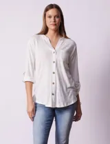 Blusa blanca texturizada marca Ninety, con cuello a la base, escote en V, abertura central con botones, bolsillo delantero y mangas tres cuartos regulables con presilla y botón.