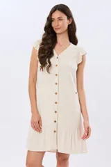 Vestido corto color beige con escote en V, sin mangas con volados en los hombros y cierre frontal de botones. Cuenta con falda con volado en el ruedo.