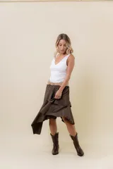 Pollera corta asimétrica de gamuza marrón oscuro, con volados superpuestos y cintura elastizada. Incluye short interno.