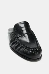 Mocasín destalonado tipo mule negro de cuero suave, con detalle fruncido en la parte delantera y punta redonda.